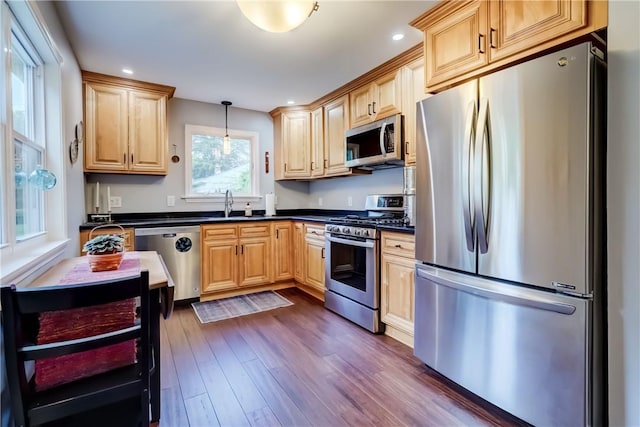 286 Park Ln, Webster, NY 14580 - kitchen with appliances with stainless steel finishes, dark countertops, dark wood-style floors, light brown cabinets, and hanging light fixtures