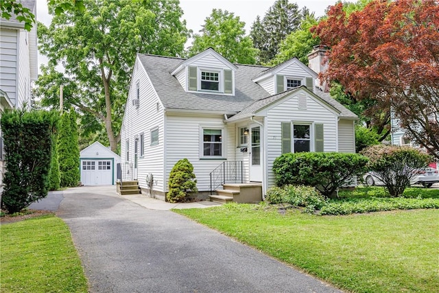 79 Meredith Ave, Brighton, NY 14618 - new england style home featuring an outdoor structure, a detached garage, a front lawn, roof with shingles, and a chimney