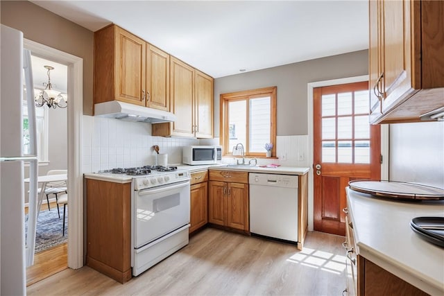 79 Meredith Ave, Brighton, NY 14618 - kitchen with white appliances, under cabinet range hood, light wood-type flooring, healthy amount of natural light, and a wainscoted wall