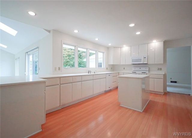 100 W Maplemere Rd, Amherst, NY 14221 - kitchen with white appliances, light wood-style flooring, white cabinets, a skylight, and recessed lighting