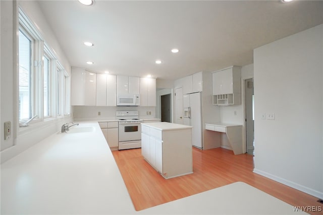 100 W Maplemere Rd, Amherst, NY 14221 - kitchen featuring white appliances, light wood-style floors, a center island, white cabinets, and recessed lighting