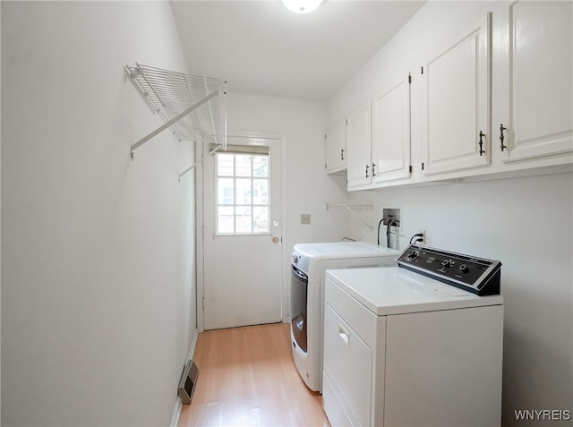 100 W Maplemere Rd, Amherst, NY 14221 - laundry area featuring cabinet space, washer and clothes dryer, and light wood-style floors