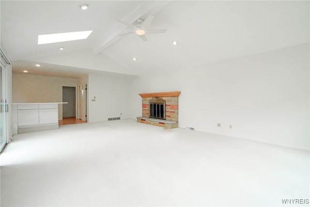 100 W Maplemere Rd, Amherst, NY 14221 - unfurnished living room featuring a skylight, a fireplace with raised hearth, a ceiling fan, light carpet, and recessed lighting