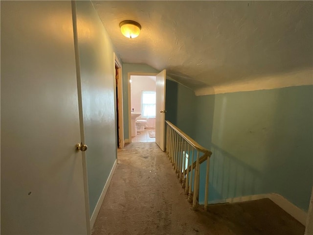 22 Jefferson St, North Dansville, NY 14437 - hallway featuring lofted ceiling, an upstairs landing, a textured ceiling, and carpet