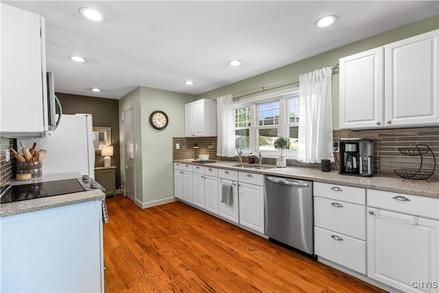 102 W Rand St, German Flatts, NY 13357 - kitchen featuring appliances with stainless steel finishes, decorative backsplash, white cabinetry, light wood-type flooring, and recessed lighting