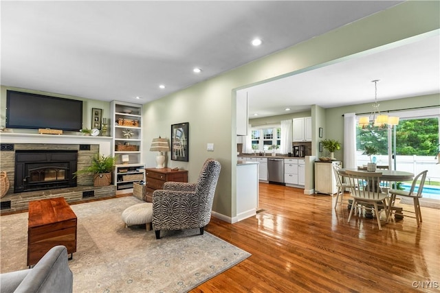 102 W Rand St, German Flatts, NY 13357 - living area featuring light wood-type flooring, a chandelier, recessed lighting, and a stone fireplace