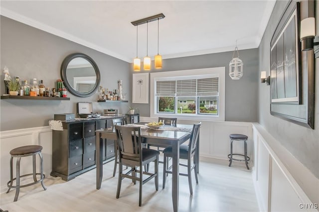 207 Baxton St, Clay, NY 13212 - dining room featuring a decorative wall, light wood-style flooring, a bar, crown molding, and a wainscoted wall