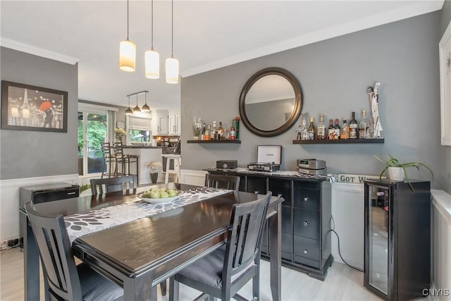 207 Baxton St, Clay, NY 13212 - dining area with light wood-type flooring, bar area, crown molding, beverage cooler, and wainscoting