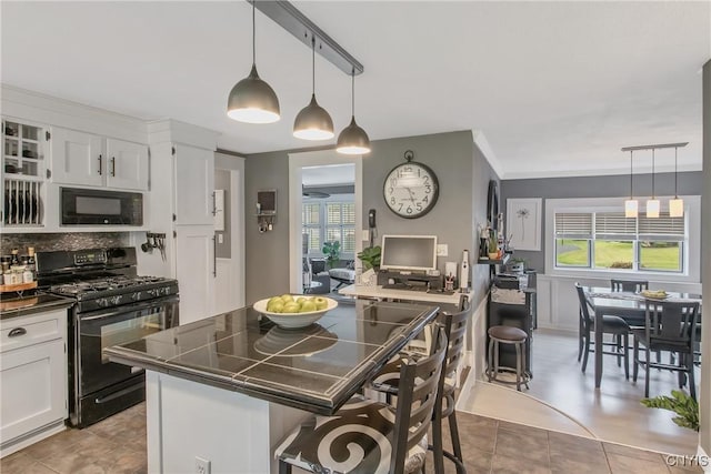 207 Baxton St, Clay, NY 13212 - kitchen featuring black appliances, a breakfast bar area, dark countertops, white cabinets, and crown molding