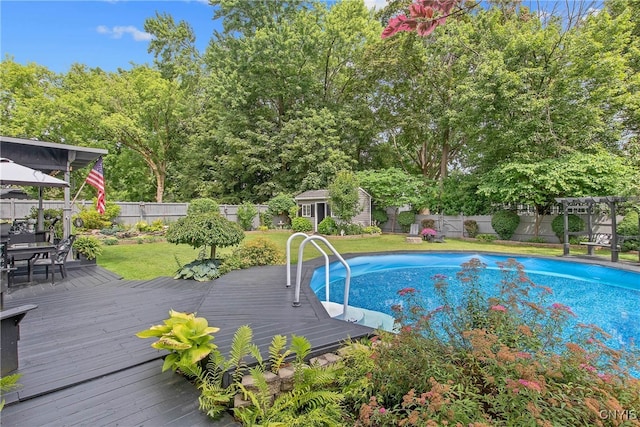 207 Baxton St, Clay, NY 13212 - view of swimming pool featuring a wooden deck, a fenced backyard, an outbuilding, outdoor dining space, and view of scattered trees