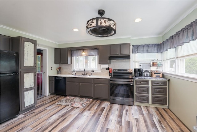 82 Maple St, Canisteo, NY 14823 - kitchen with black appliances, healthy amount of natural light, under cabinet range hood, light countertops, and crown molding