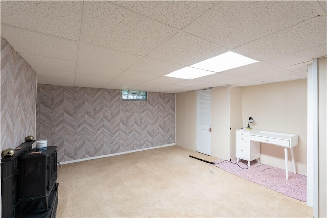 82 Maple St, Canisteo, NY 14823 - finished basement featuring carpet flooring, a wood stove, a drop ceiling, and wallpapered walls