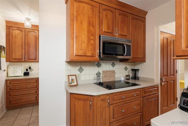 83 Bryant # 7Ab, Buffalo, NY 14209 - kitchen featuring stainless steel microwave, black electric stovetop, light countertops, and tasteful backsplash