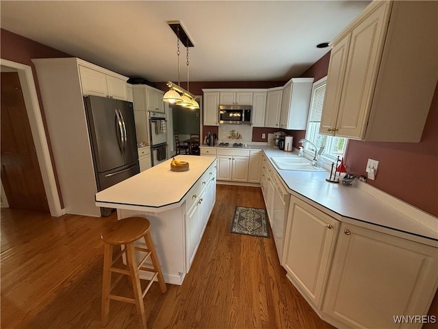26 Forestglen Cir, Amherst, NY 14221 - kitchen with stainless steel appliances, dark wood-style floors, white cabinets, a kitchen island, and light countertops