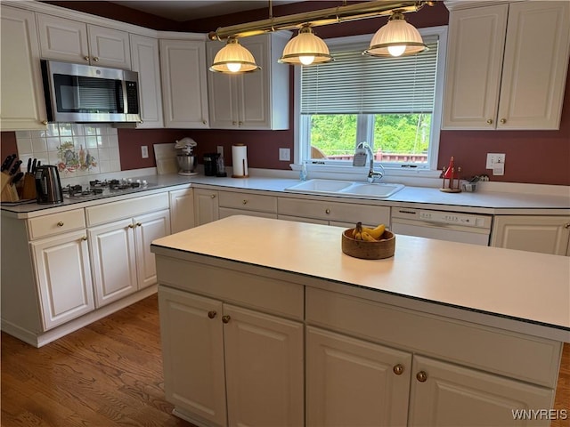26 Forestglen Cir, Amherst, NY 14221 - kitchen with stainless steel microwave, gas cooktop, white cabinets, light countertops, and wood finished floors