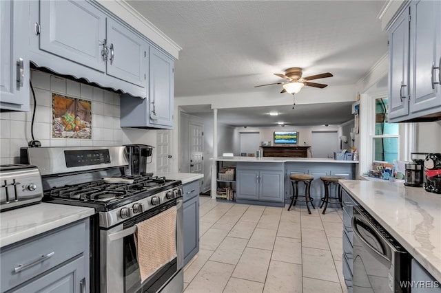 112 Creekview Dr, West Seneca, NY 14224 - kitchen with stainless steel range with gas stovetop, dishwasher, ceiling fan, gray cabinets, and a peninsula