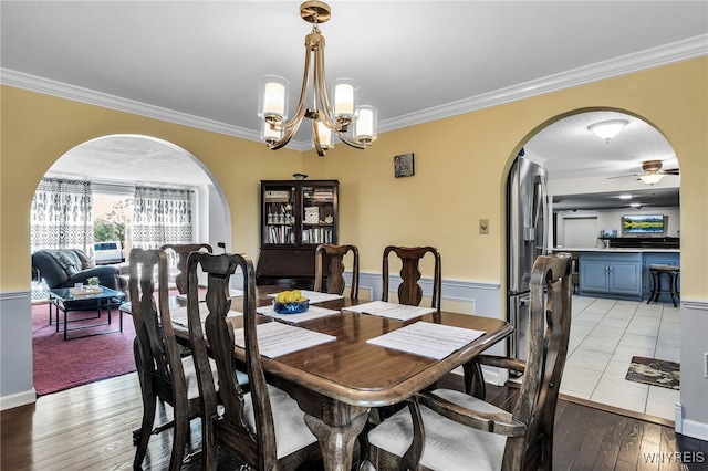 112 Creekview Dr, West Seneca, NY 14224 - dining area featuring arched walkways, ornamental molding, a chandelier, light wood-style flooring, and ceiling fan