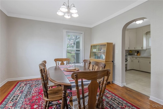505 Tompkins St, Syracuse, NY 13204 - dining room with arched walkways, light wood-style flooring, a chandelier, and crown molding