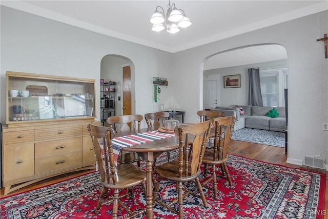 505 Tompkins St, Syracuse, NY 13204 - dining room featuring arched walkways, wood finished floors, and a chandelier