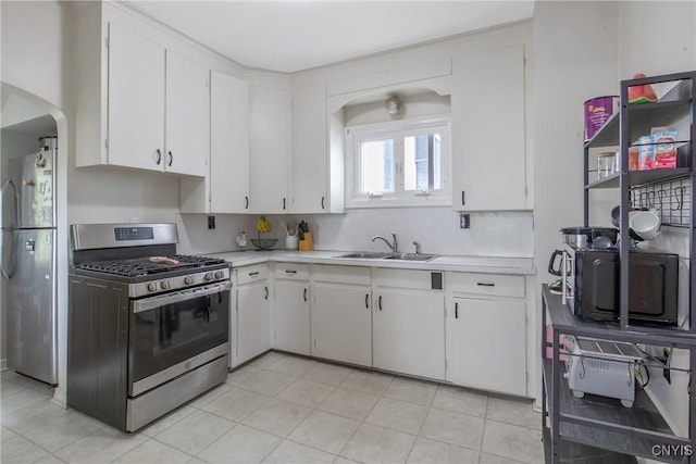505 Tompkins St, Syracuse, NY 13204 - kitchen featuring appliances with stainless steel finishes, light countertops, white cabinetry, and arched walkways
