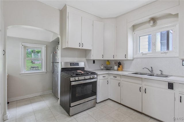 505 Tompkins St, Syracuse, NY 13204 - kitchen with gas stove, arched walkways, light countertops, and white cabinets