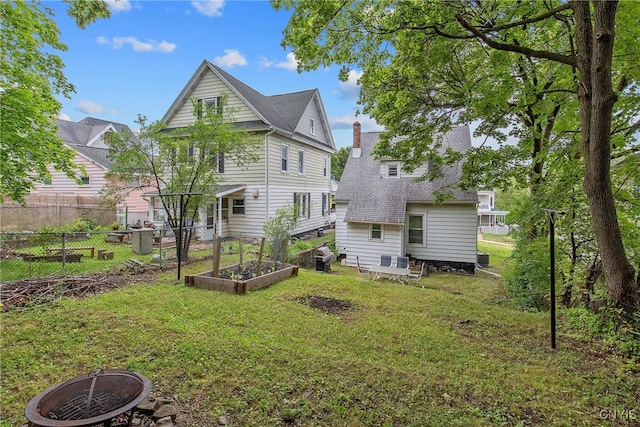 505 Tompkins St, Syracuse, NY 13204 - rear view of property with an outdoor fire pit, a vegetable garden, and roof with shingles