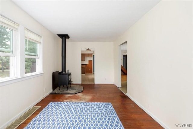 5156 Fairgrounds Rd, Hamburg, NY 14075 - unfurnished living room featuring a wood stove and dark wood finished floors