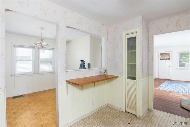 5156 Fairgrounds Rd, Hamburg, NY 14075 - kitchen with wallpapered walls, a wainscoted wall, hanging light fixtures, and light floors