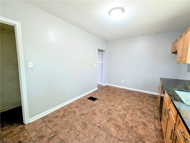 883 Brown Rd, Irondequoit, NY 14622 - kitchen featuring baseboards and dark stone counters