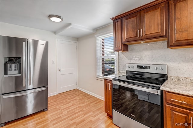 445 75th St, Niagara Falls, NY 14304 - kitchen with stainless steel appliances, decorative backsplash, light wood-type flooring, and brown cabinets
