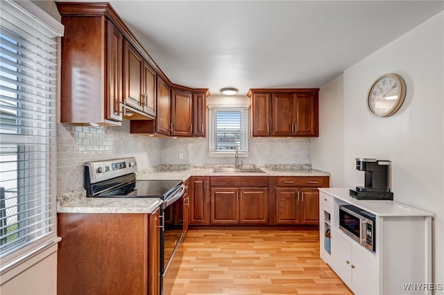 445 75th St, Niagara Falls, NY 14304 - kitchen featuring stainless steel appliances, light wood-style floors, tasteful backsplash, and light countertops