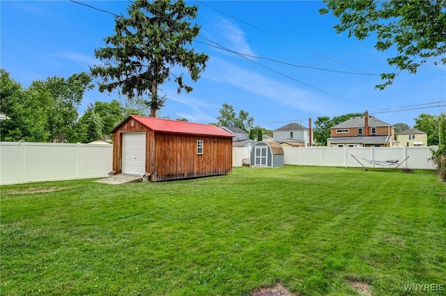 445 75th St, Niagara Falls, NY 14304 - fenced backyard featuring a storage unit and a detached garage