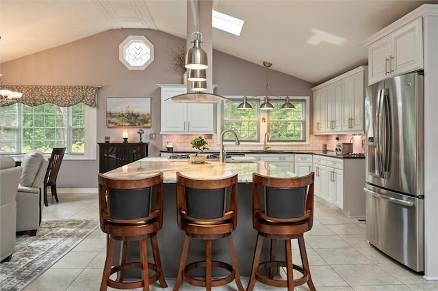 798 Hawthorne Pl, Webster, NY 14580 - kitchen featuring stainless steel fridge, lofted ceiling, light tile patterned flooring, tasteful backsplash, and white cabinetry
