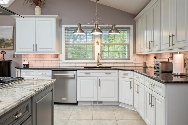 798 Hawthorne Pl, Webster, NY 14580 - kitchen with stainless steel appliances, vaulted ceiling, decorative backsplash, light tile patterned floors, and white cabinetry