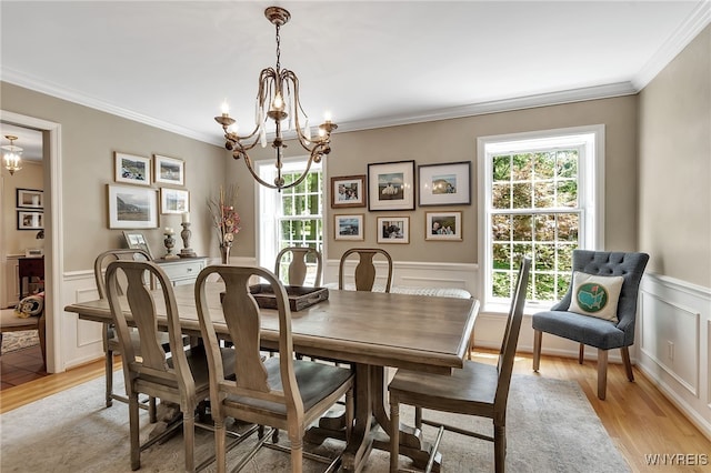 29 Cherry Tree Ln, Orchard Park, NY 14127 - dining space with a chandelier, a decorative wall, light wood-style floors, ornamental molding, and wainscoting
