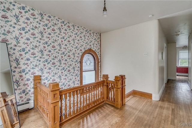 210 N James St, Wilna, NY 13619 - hallway with an upstairs landing, wallpapered walls, wood-type flooring, and a baseboard radiator