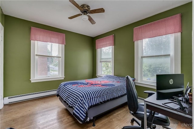 210 N James St, Wilna, NY 13619 - bedroom with a baseboard radiator, multiple windows, a desk, and wood finished floors
