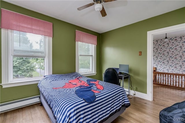 210 N James St, Wilna, NY 13619 - bedroom with a baseboard heating unit, multiple windows, and wood finished floors