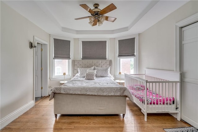 210 N James St, Wilna, NY 13619 - bedroom with a tray ceiling, light wood-style flooring, and ceiling fan