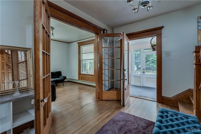 210 N James St, Wilna, NY 13619 - foyer with baseboard heating, wood finished floors, french doors, and a chandelier