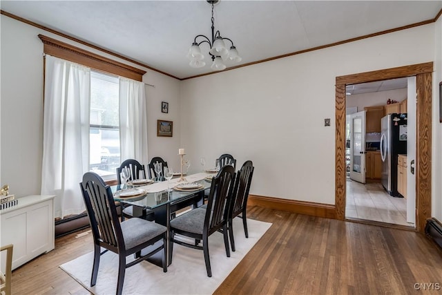 210 N James St, Wilna, NY 13619 - dining area featuring crown molding, light wood-style floors, a chandelier, and a baseboard heating unit