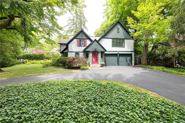 8 Oak Ln, Brighton, NY 14610 - tudor house featuring an attached garage, driveway, and stone siding