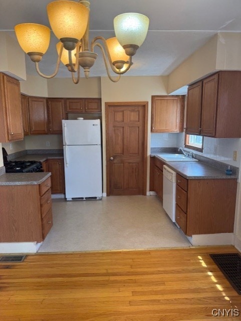 308 Wayland Rd, Salina, NY 13208 - kitchen featuring white appliances, brown cabinetry, dark countertops, and tasteful backsplash
