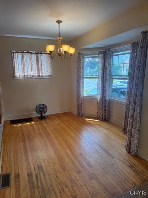 308 Wayland Rd, Salina, NY 13208 - unfurnished room featuring wood finished floors and a chandelier