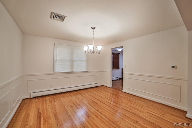 46 Macarthur Dr, Amherst, NY 14221 - empty room with a baseboard heating unit, a chandelier, light wood-style floors, a wainscoted wall, and a decorative wall