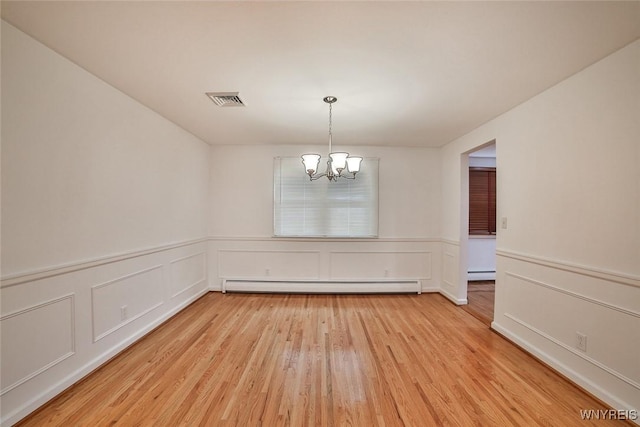 46 Macarthur Dr, Amherst, NY 14221 - unfurnished room featuring a baseboard heating unit, a chandelier, light wood finished floors, wainscoting, and a decorative wall