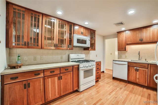 46 Macarthur Dr, Amherst, NY 14221 - kitchen featuring white appliances, brown cabinets, backsplash, light wood-type flooring, and recessed lighting