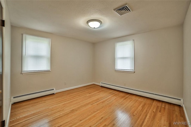 46 Macarthur Dr, Amherst, NY 14221 - empty room with a baseboard heating unit, wood finished floors, and a textured ceiling