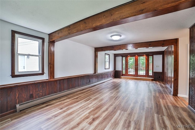 46 Macarthur Dr, Amherst, NY 14221 - unfurnished room featuring baseboard heating, wood finished floors, wood walls, beamed ceiling, and a wainscoted wall