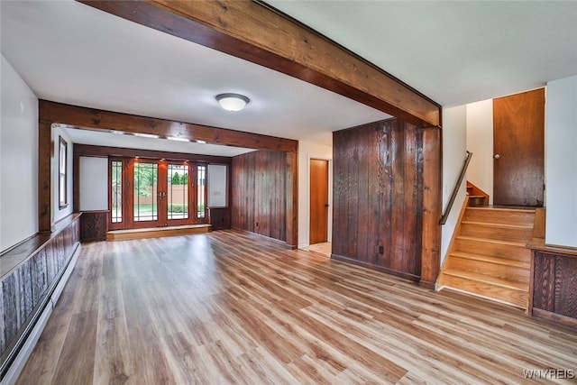 46 Macarthur Dr, Amherst, NY 14221 - unfurnished living room featuring a baseboard radiator, light wood finished floors, stairway, beam ceiling, and wood walls